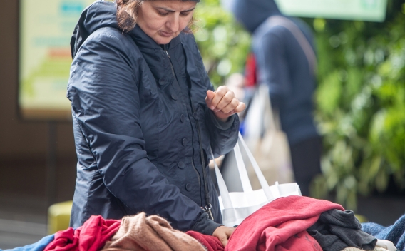 Woman browses through clothing items on display