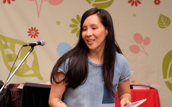 Woman on stage holding a picture book