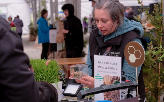 Woman chatting with visitor at an environmental teaching demo